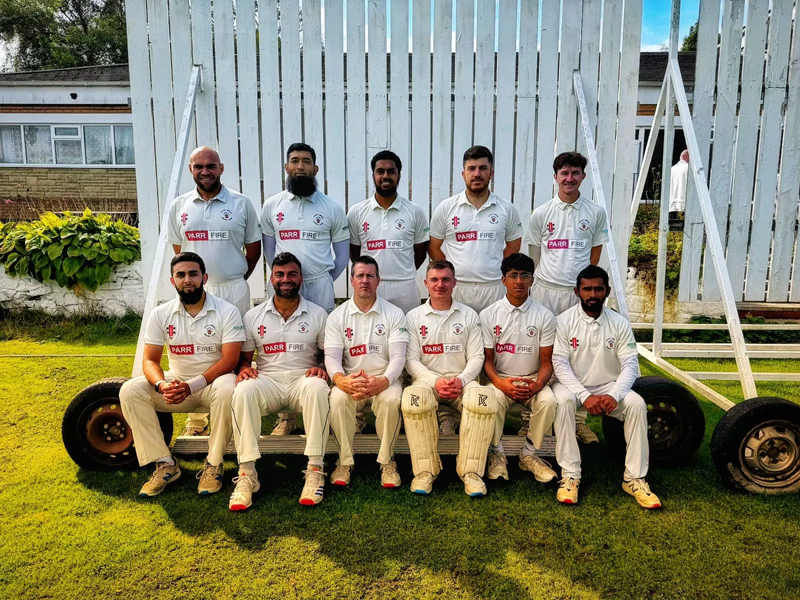 2024 Team photo in white cricket kit.